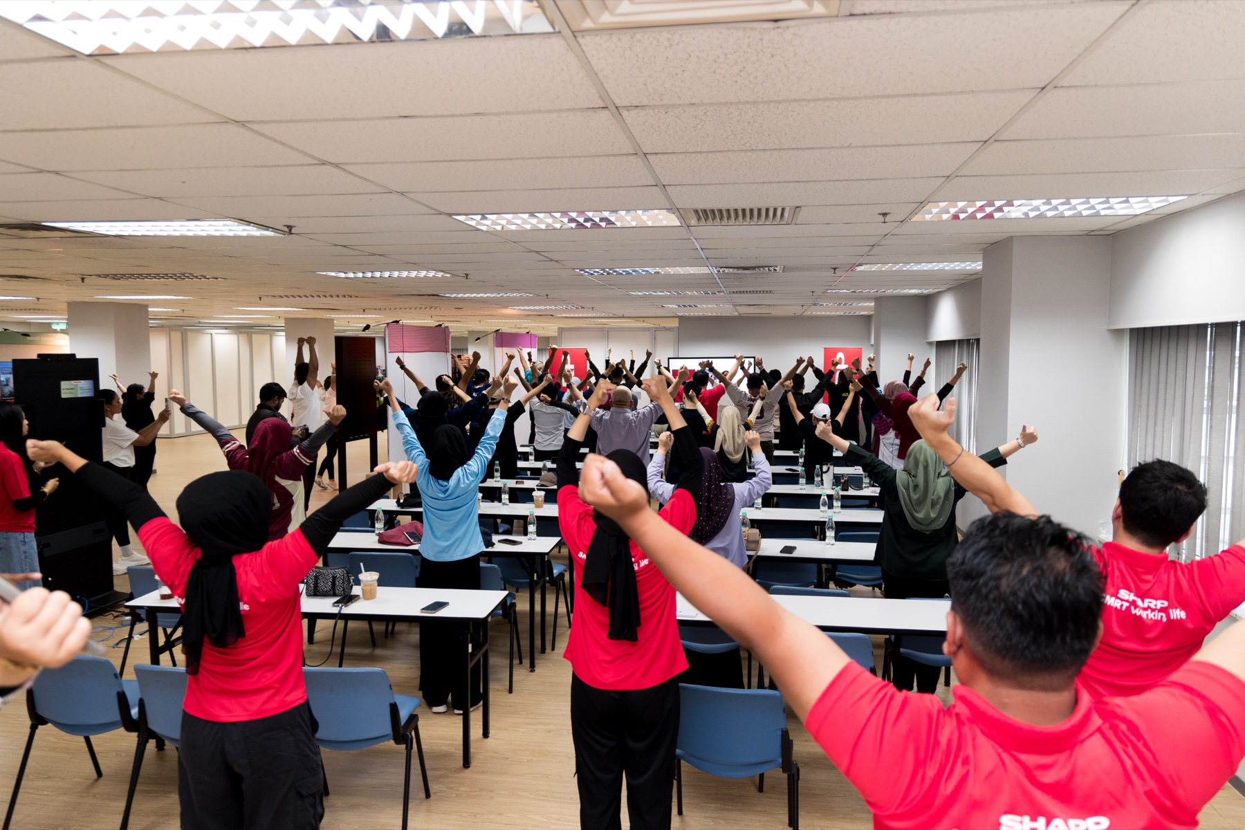 Group wellness session with raised hands